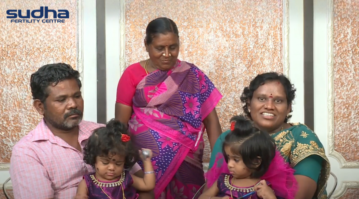 Happy Couple with their family holding twin girl babies after Natural Conception through IVF at Sudha Fertility Centre Chennai- Available at Tamil Nadu, Karnataka, Andhra Pradesh, Pondicherry, and Telangana